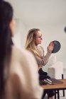 Vista laterale di psicologa donna con placca gesticolante e dare consigli a cliente irriconoscibile durante l'appuntamento di psicoterapia — Foto stock