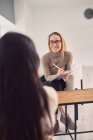 Fröhliche Beraterin hört anonymen Klienten zu, während sie während einer psychologischen Therapiesitzung hilft — Stockfoto