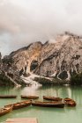 Toller Blick auf die Dolomiten mit grünem Seewasser, das raue, mit Nebel und Wolken bedeckte Felshänge in Italien reflektiert — Stockfoto
