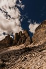 Espectacular paisaje de la cordillera Dolomita con ásperos picos rocosos bajo el cielo azul nublado a la luz del día en Italia - foto de stock