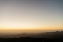 Tramonto sulla catena montuosa sullo sfondo del cielo senza nuvole la sera — Foto stock