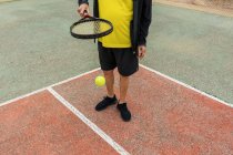 Crop senior sportsman bouncing ball on racket while preparing for tennis match on court — Stock Photo