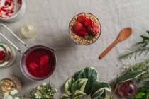 Composition vue du dessus du verre de délicieuse boisson aux baies fraîches garnie de fraises coupées et de noix servies sur la table — Photo de stock