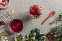 Top view composition of glass of delicious fresh berry drink garnished with cut strawberries and nuts served on table — Stock Photo