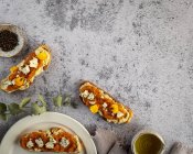 Вид сверху аппетитный свежие тосты с джемом и козьим сыром подается на тарелки и мраморный стол — стоковое фото