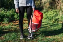 Caminhante feminina anônima com mochila em pé na floresta — Fotografia de Stock