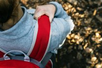 Vue du dessus d'une randonneuse anonyme avec sac à dos debout dans la forêt — Photo de stock