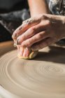 Crop unrecognizable craftswoman creating earthenware on pottery wheel in studio — Stock Photo