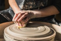 Crop unrecognizable craftswoman creating earthenware on pottery wheel in studio — Stock Photo