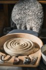 Брудне гончарне колесо та глина розміщені зі стільцем у творчій майстерні художника — стокове фото