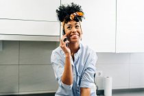 Internet afroamericano di lingua femminile su smartphone mentre si trova in piano di lavoro in cucina al mattino — Foto stock