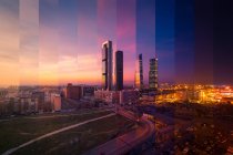 Contemporary skyscraper and multistory house exteriors against roadway and shiny light posts in Madrid at sunset — Stock Photo