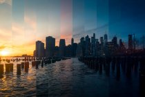 East River em Nova York com arranha-céus contemporâneos sob céu nublado ao pôr do sol — Fotografia de Stock