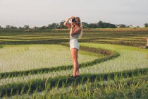Жінка-блондинка робить фотографії на рисовому полі в Кайсі. — стокове фото