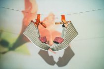 Trendige Sandalen hängen im Sommer an Seil an Wand mit Blume — Stockfoto