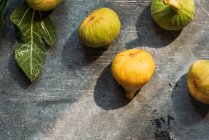 Ripe sweet green figs, freshly harvested from domestic tree, on table with grunge texture. Also known as ripe white figs — Stock Photo