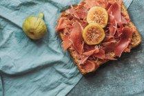 Delicious toast of Iberico ham, cheese and fresh figs on the blue tablecloth, Delicious appetizer, ideal as an aperitif. Healthy food — Stock Photo