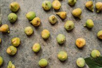 Спелые сладкие зеленые инжиры, свежесобранные с домашнего дерева, на гранжевой текстуре сверху. Также известный как спелые белые инжиры — стоковое фото