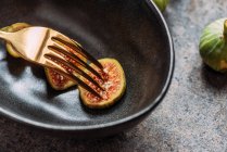 Green fig slices in modern black bowl on the table with grunge texture. minimal concept food. Also known as ripe white figs — Stock Photo