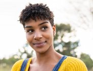 Frohe Afroamerikanerin mit Afro-Frisur und im trendigen Outfit im Park — Stockfoto