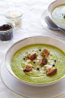Von oben leckere Zucchini-Cremesuppe mit Croutons in Schüssel auf dem heimischen Tisch serviert — Stockfoto