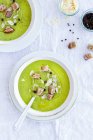 From above of yummy zucchini cream soup with croutons in bowls served on table at home — Stock Photo