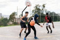 Multiethnische Freunde spielen im Sommer Streetbasketball auf Sportplatz — Stockfoto