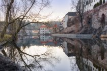 Malerischer Blick auf alte schäbige Wohnhäuser, die sich im ruhigen Wasser des Flusses spiegeln — Stockfoto