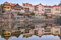 Vue pittoresque de vieux bâtiments résidentiels minables se reflétant dans les eaux calmes de la rivière — Photo de stock