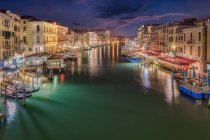 Vista panorámica del Gran Canal entre antiguos edificios residenciales bajo el cielo nocturno en Venecia - foto de stock