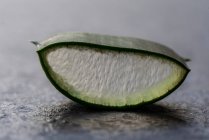 Closeup of cut aloe vera piece of leaf placed on table in studio — Stock Photo