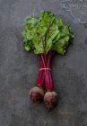 From above of bunch of beet placed on black shabby background in studio — Stock Photo