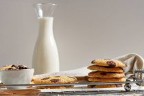 Delicious homemade sweet cookies with chocolate ships served on tray with glass jar of milk — Stock Photo
