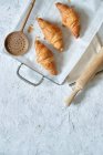 Vista dall'alto di deliziosi croissant freschi disposti su vassoio di metallo sul tavolo in cucina — Foto stock