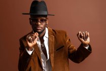 Junger afroamerikanischer Mann in trendiger Kleidung und Hut tanzt und schaut weg — Stockfoto