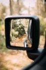 Rear view of an off-road car driving through a mountain road — Stock Photo