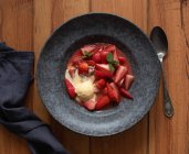 Vista dall'alto di gustose metà fragola con gelato alla vaniglia in piatto sul tavolo di legno — Foto stock