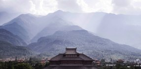 Часть изогнутой крыши древнего буддийского храма, расположенного в горах Юньнаня — стоковое фото