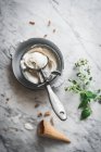 Dall'alto del cono di cialde vicino a misurini di gelato al latte di meringa e foglie di menta fresca sul tavolo di marmo — Foto stock