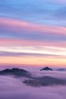 Atemberaubende Landschaft mit wolkenverhangenen Berggipfeln unter farbenfrohem Sonnenuntergang im Sierra de Guadarrama Nationalpark — Stockfoto