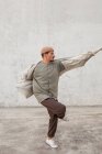 Vista lateral de talentoso bailarín masculino breakdance en amplio pasaje en el área urbana - foto de stock