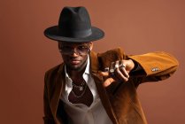 Junger afroamerikanischer Mann in trendiger Kleidung und Hut tanzt in die Kamera — Stockfoto