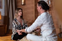 Side view of Zen teacher with female partner sitting with crossed legs and closed eyes during spiritual practice — Stock Photo