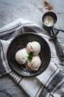 Vista superior de gelato saboroso com folhas de hortelã fresca e canela em pó no topo perto scooper na toalha — Fotografia de Stock