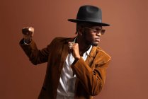 Jovem afro-americano masculino na moda vestuário e chapéu dançando olhando para longe — Fotografia de Stock