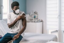 Paziente afroamericano che detiene cotone con alcol disinfettante braccio dopo procedura vaccinale covid in clinica durante l'epidemia di coronavirus — Foto stock