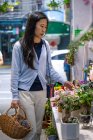Belle fille asiatique acheter des fleurs dans la boutique de fleurs — Photo de stock
