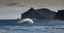 Pintoresca vista del mar Cantábrico con olas rápidas contra los montes en Bakio en la provincia de Vizcaya España - foto de stock