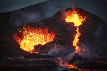 Primer plano Volcán Fagradalsfjall en erupción en Islandia entre nubes de humo - foto de stock