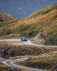 Auto moderna guida su un sentiero polveroso tra le verdi montagne dei Pirenei con foresta in Spagna — Foto stock